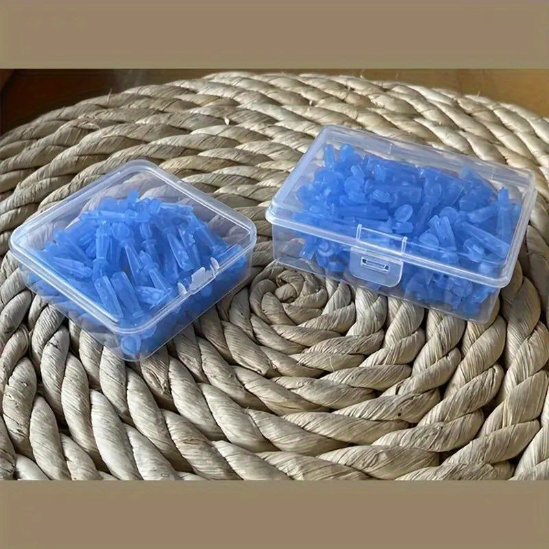 Two clear plastic boxes filled with blue, disposable acne needle tools resting on a woven straw mat.