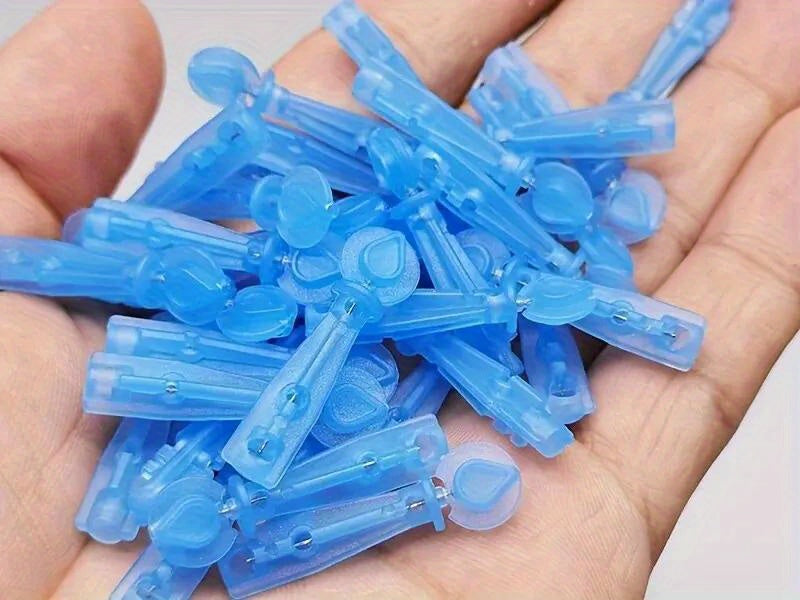 A handful of disposable, blue plastic lancet needles for facial cleaning held in an open palm.