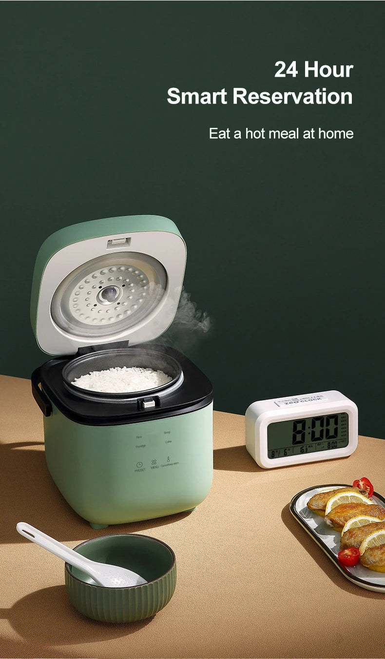 Mini electric rice cooker with lid open and steam rising, mint green body on countertop