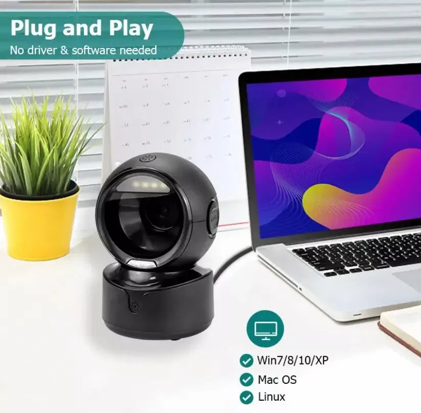 Black barcode scanner on stand beside a laptop screen and desktop items