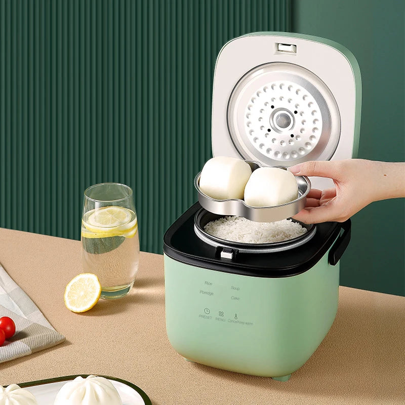 Mini electric rice cooker, mint teal body with open lid steaming plate and eggs inside