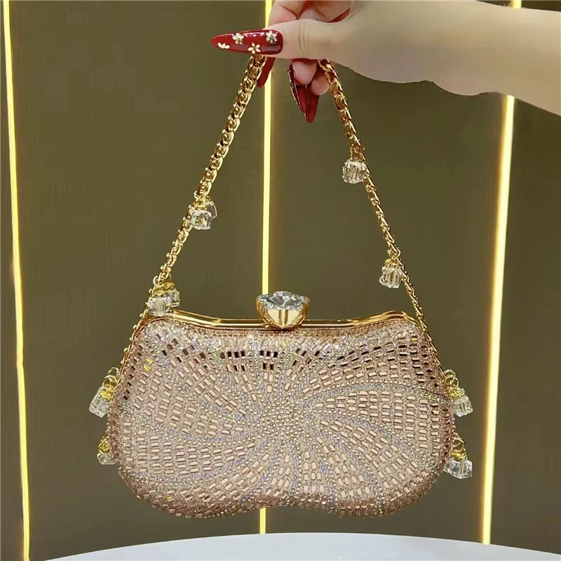 Rose gold designer clutch handbag with rhinestone embellishments, gold chain strap, and crystal clasp.