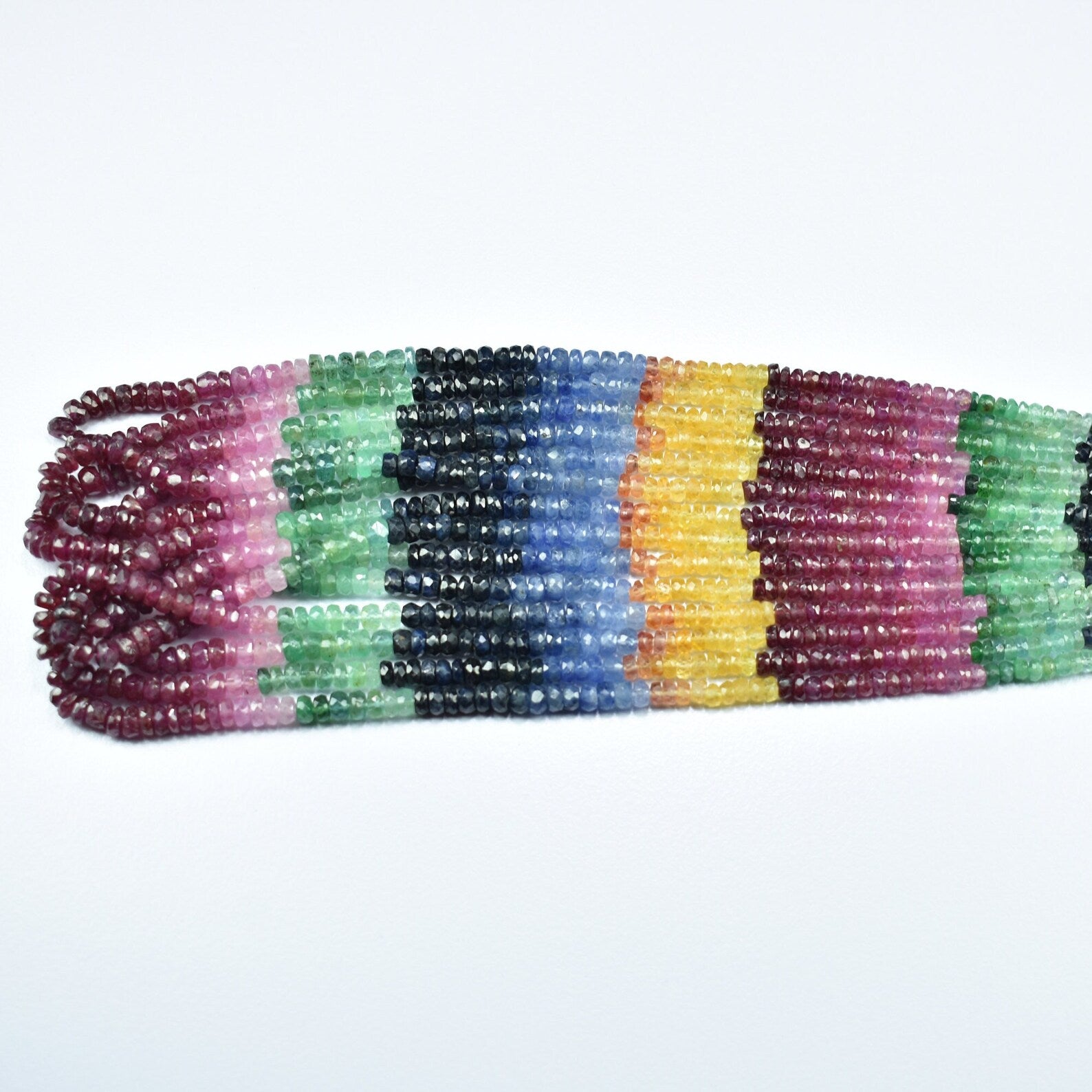 Flat view multicolor faceted rondelle bead strand with maroon, green, blue, and yellow blocks