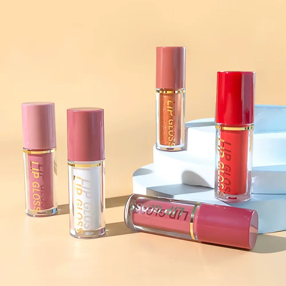Set of nude lip glosses with matte, metallic, and glitter finishes in clear tubes on a minimalist display stand.