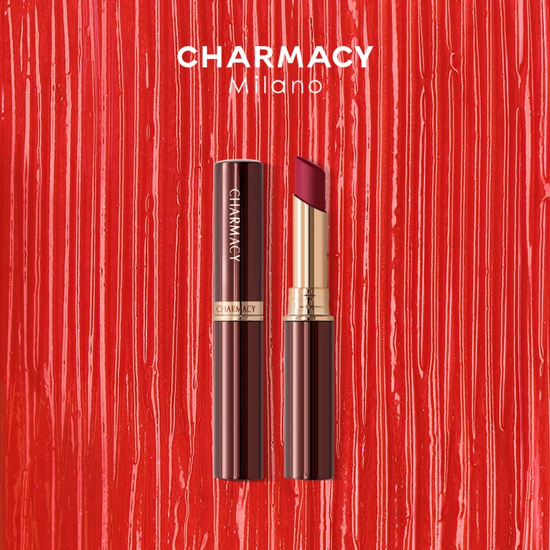 Charmacy waterproof velvet matte lipstick in a sleek gold and brown tube on a red smear textured background.