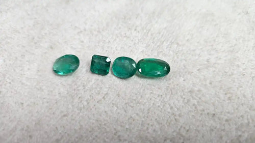 Loose green emerald-cut gemstone mix, five small stones in mixed shapes on felt