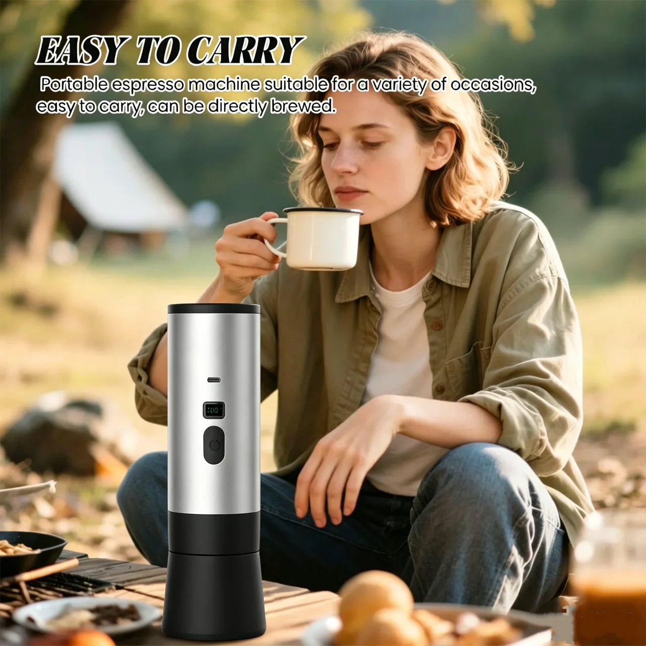 Silver and black portable electric espresso maker for camping and travel on a wooden table.
