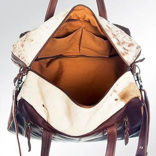 Open vintage-style unisex travel duffel in brown leather and white cowhide with internal storage pockets.
