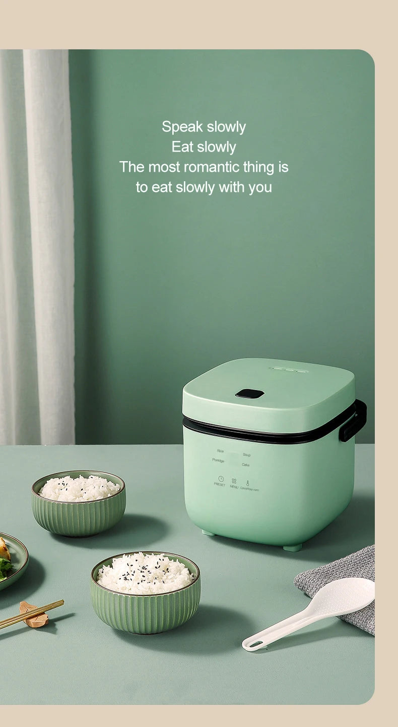 Mini electric rice cooker in mint green with top lid and control markings, countertop-ready design