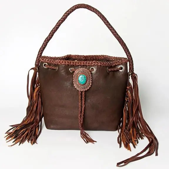 Vintage brown leather bucket bag with fringe, braided handle, and decorative turquoise stone accent.
