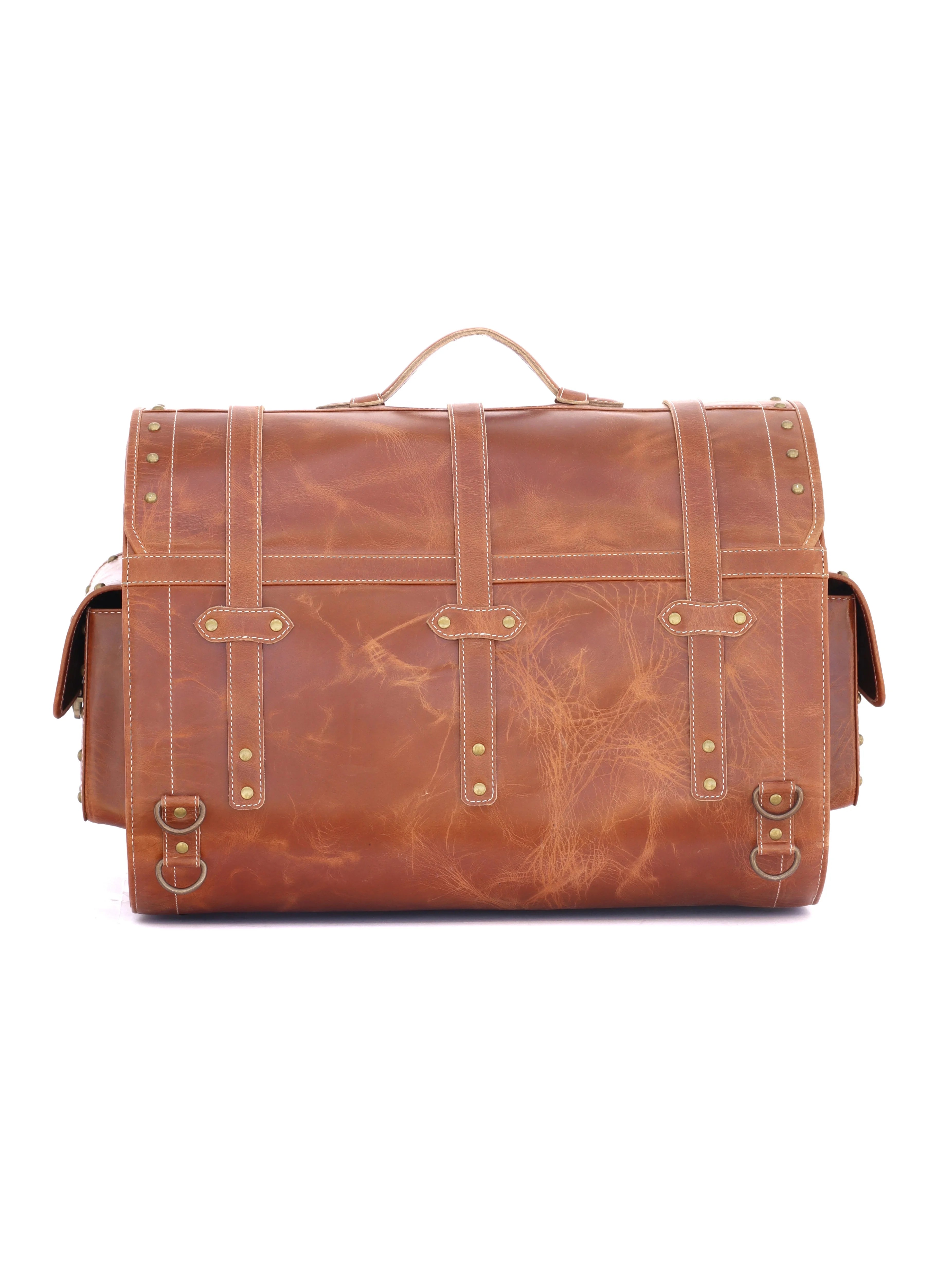 RABADA vintage brown leather travel trunk with heavy-duty straps, brass stud detailing, and side pockets for luggage.