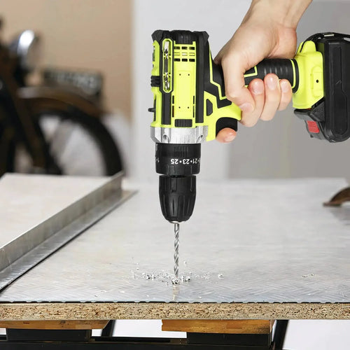 Handheld cordless drill in lime and black driving a screw into a metal surface