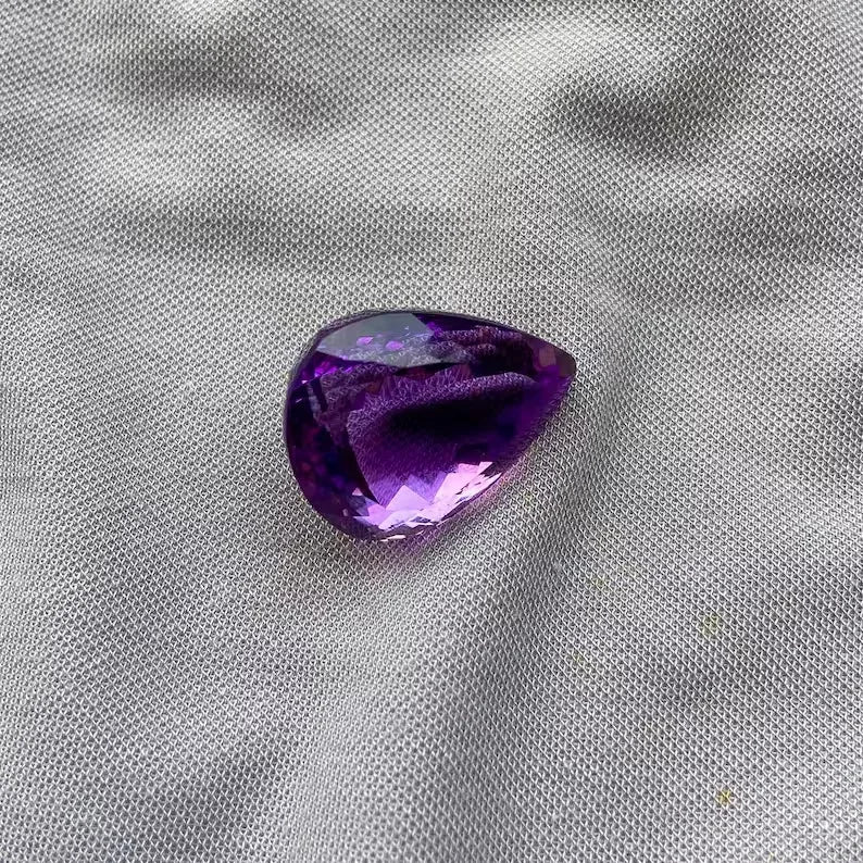 Pear-cut amethyst gemstone, purple teardrop with faceted surface