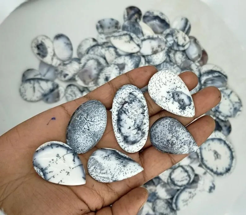 Handheld set of oval dendrite opal cabochon stones, white with black speckles