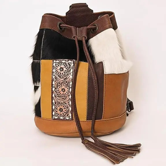 Western-style bucket bag in cowhide and leather, featuring floral embossed panels, tassel drawstring, and multicolor.