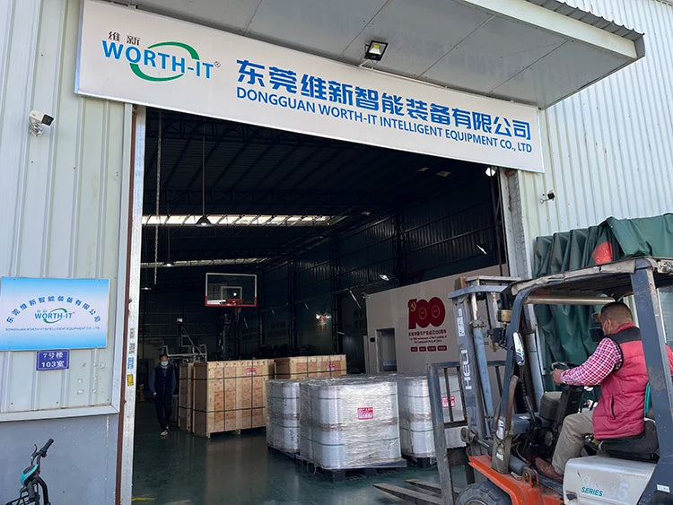Industrial packaging bay with stacked cardboard cartons near a machinery doorway