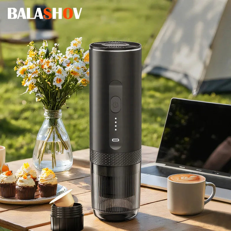 Balashov portable black electric espresso maker with battery indicator, used for coffee capsules on an outdoor table.