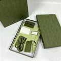 Olive green designer trunk box packaging with matching dust bag, leather strap, and product tags for a crossbody bag.