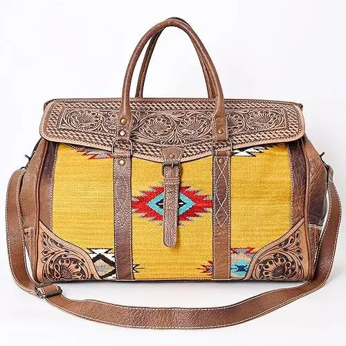 Bohemian trunk bag in yellow Aztec saddle blanket fabric with brown hand-tooled leather trim and adjustable strap.