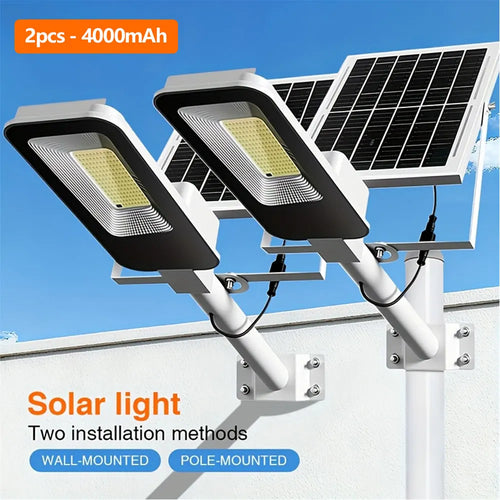 Two wall-mounted solar street lights with black LED heads and solar panels on white brackets