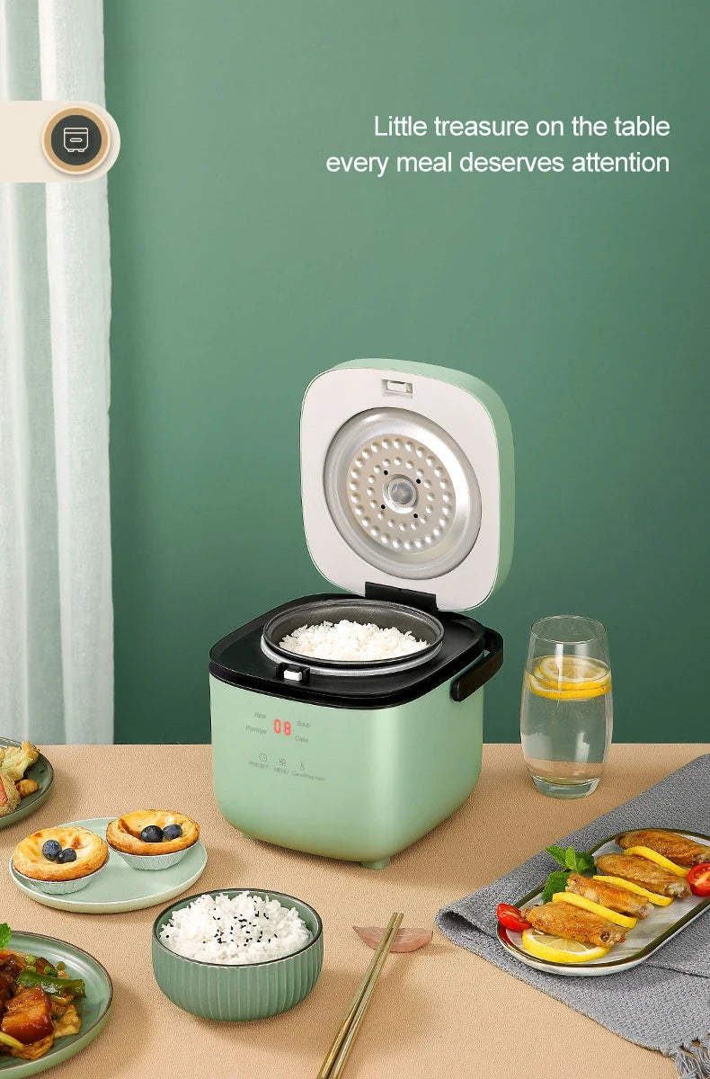 Mini electric rice cooker with green body and open lid, rice visible inside.