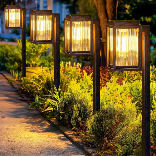 Solar pathway garden lights with black lantern heads on ground spikes, warm amber glow
