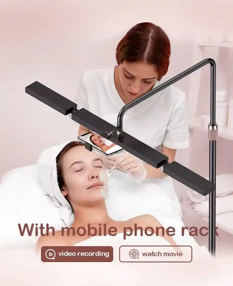 Black adjustable floor stand with linear LED light and integrated smartphone holder for filming skincare treatments.