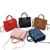 Set of five luxury designer PU leather crossbody handbags in red, black, brown, pink, and blue with top handles.