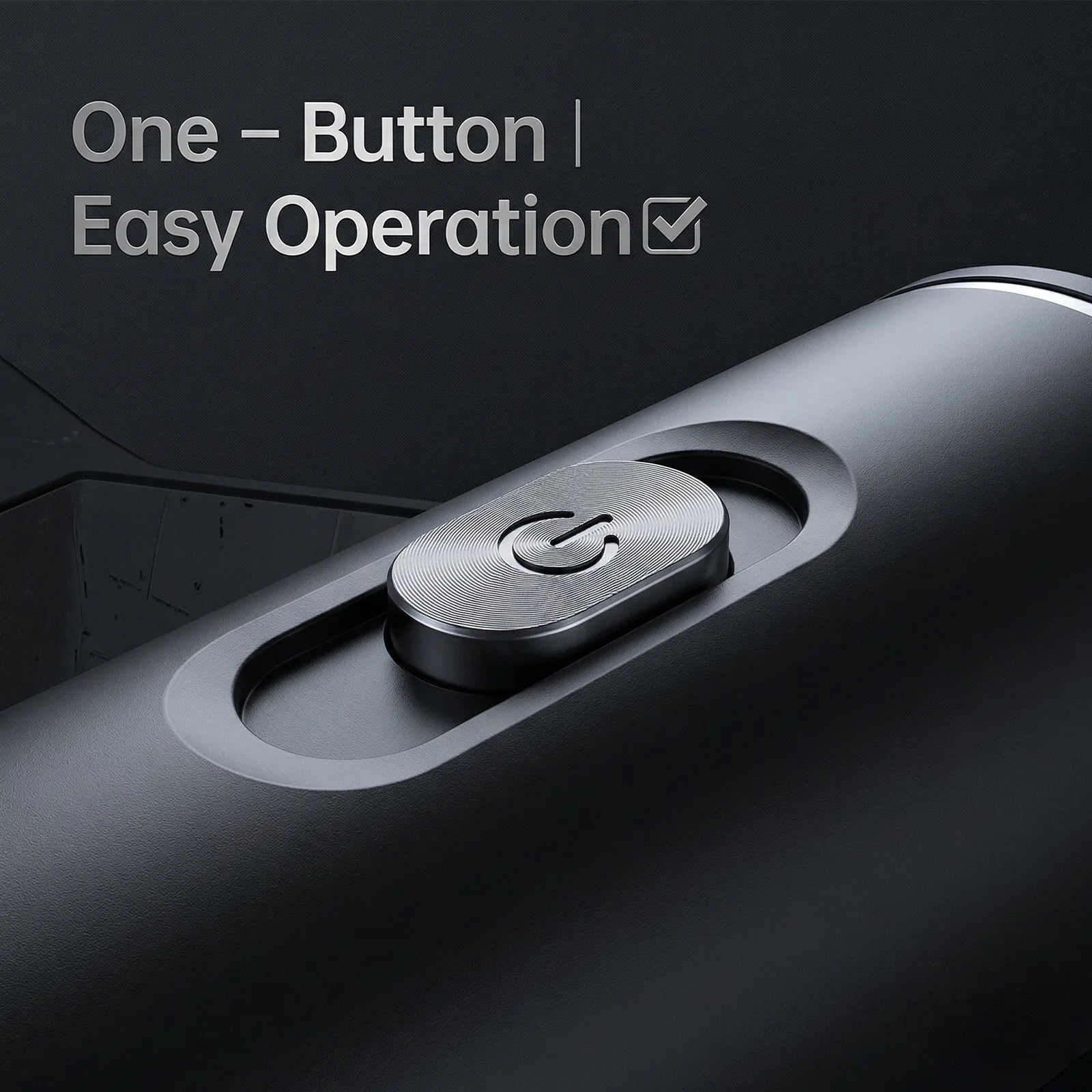 Close-up of a matte black portable coffee maker showing the metallic one-button power operation control.