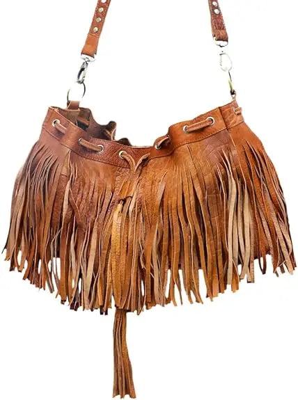Tan leather bucket shoulder bag with fringe, drawstring closure, and crossbody strap. Boho style trunk handbag.