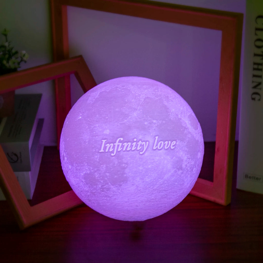 Purple glowing moon lamp with textured surface and the words Infinity love printed on the front, used for ambient light.