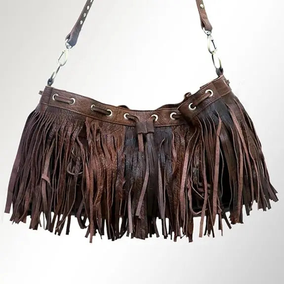 Brown leather boho bucket shoulder bag with fringe detailing, silver grommets, and adjustable crossbody strap.