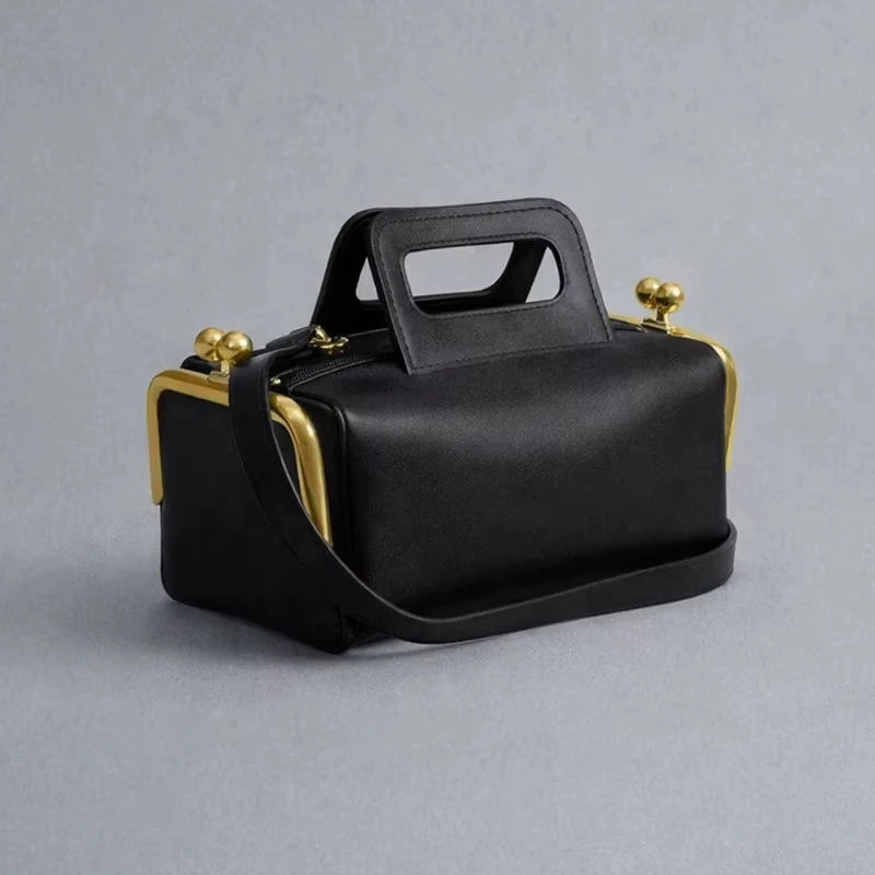 Black retro PU leather handbag with gold frame clasp, structured pillow shape, and top handle. Designer shoulder bag.