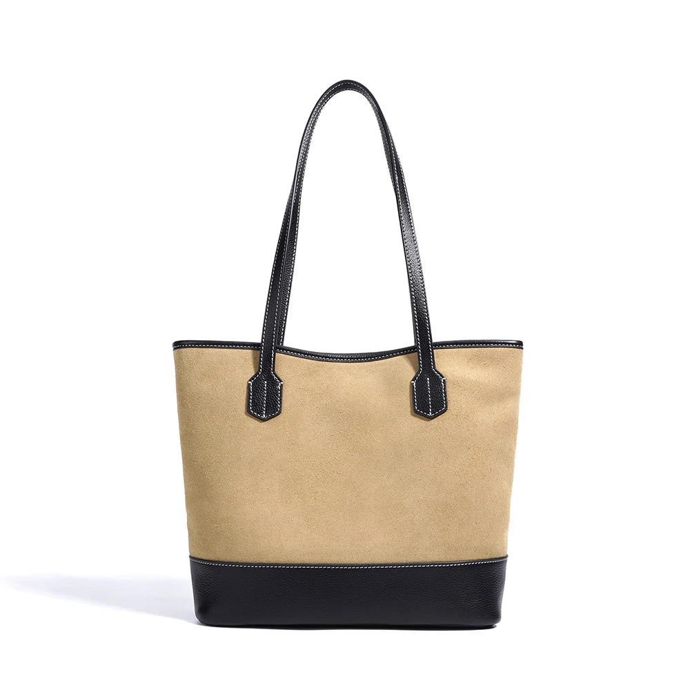 Vintage-style tan suede underarm tote with black leather trim, contrast stitching, and minimalist shoulder straps.