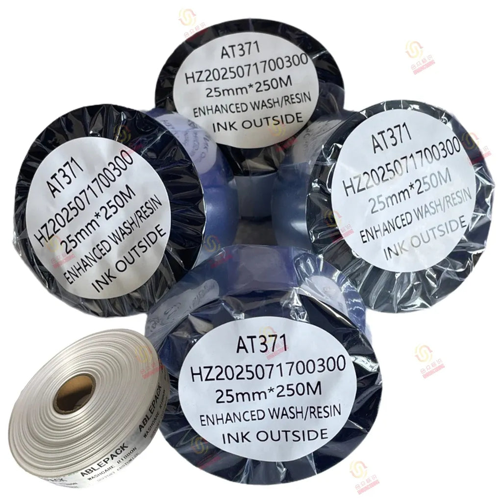 Assorted black resin ribbon spools with AT371 labels and white backing roll