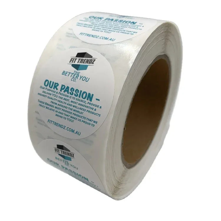 White roll of custom printed packaging label stickers, angled view, blue text logos
