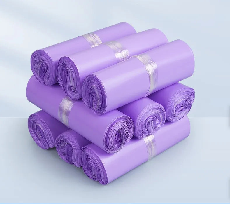 Rolled plastic mailing bags, lavender, stacked with red securing bands