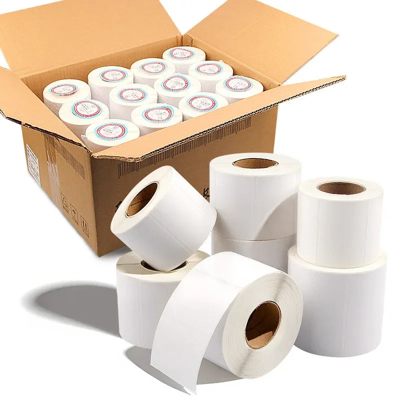 White roll label stickers stacked beside a cardboard shipping box