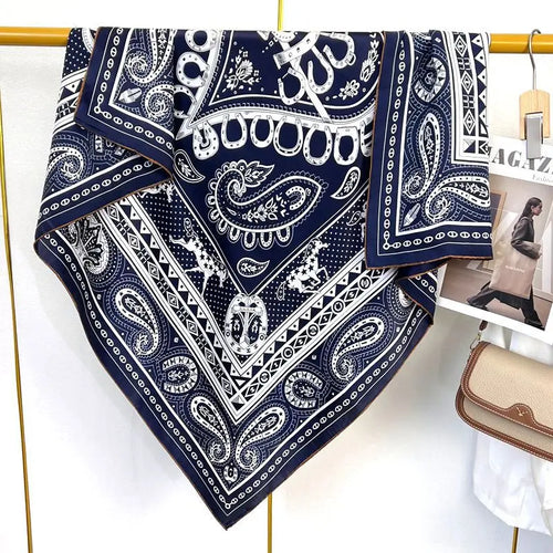Luxury navy blue square silk scarf with white paisley print, equestrian horse and horseshoe motifs.