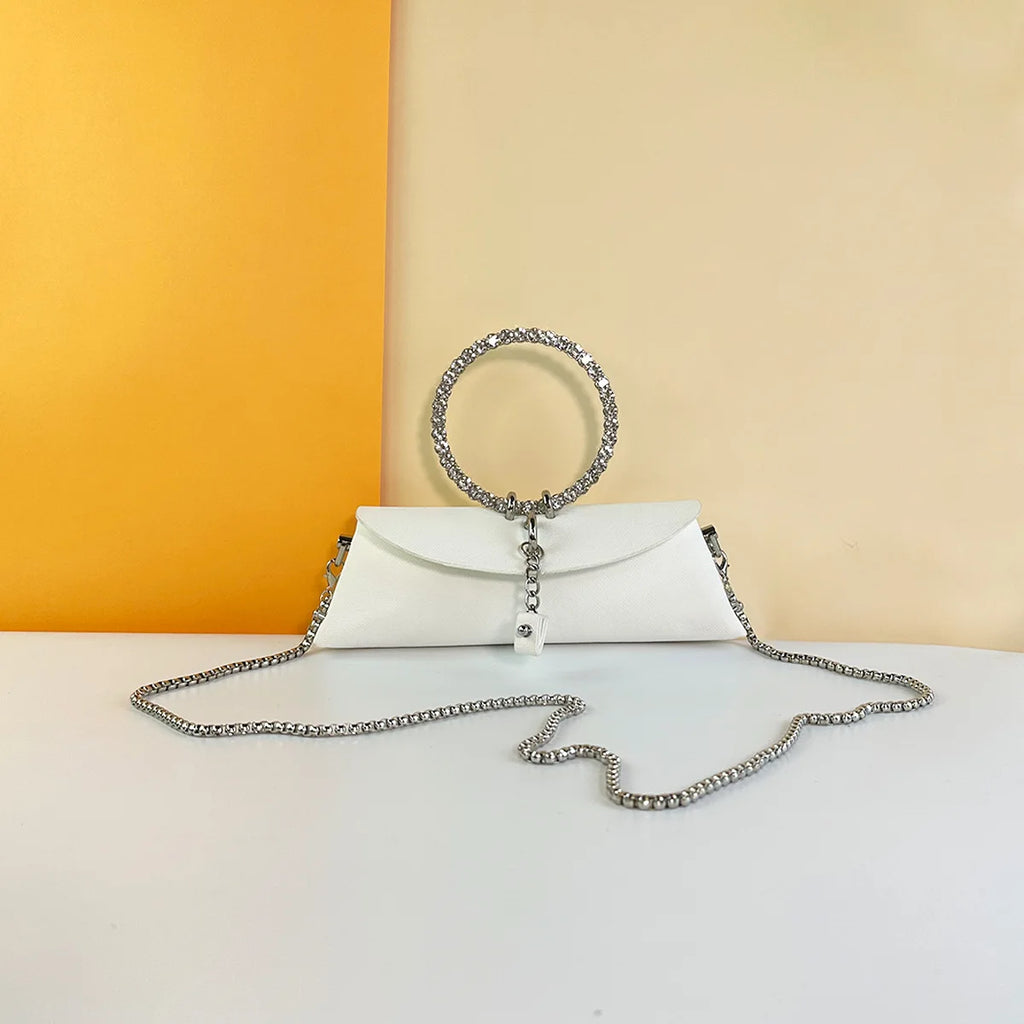 White PU leather evening clutch with crystal ring handle, silver chain strap, and elegant wedding trunk style.