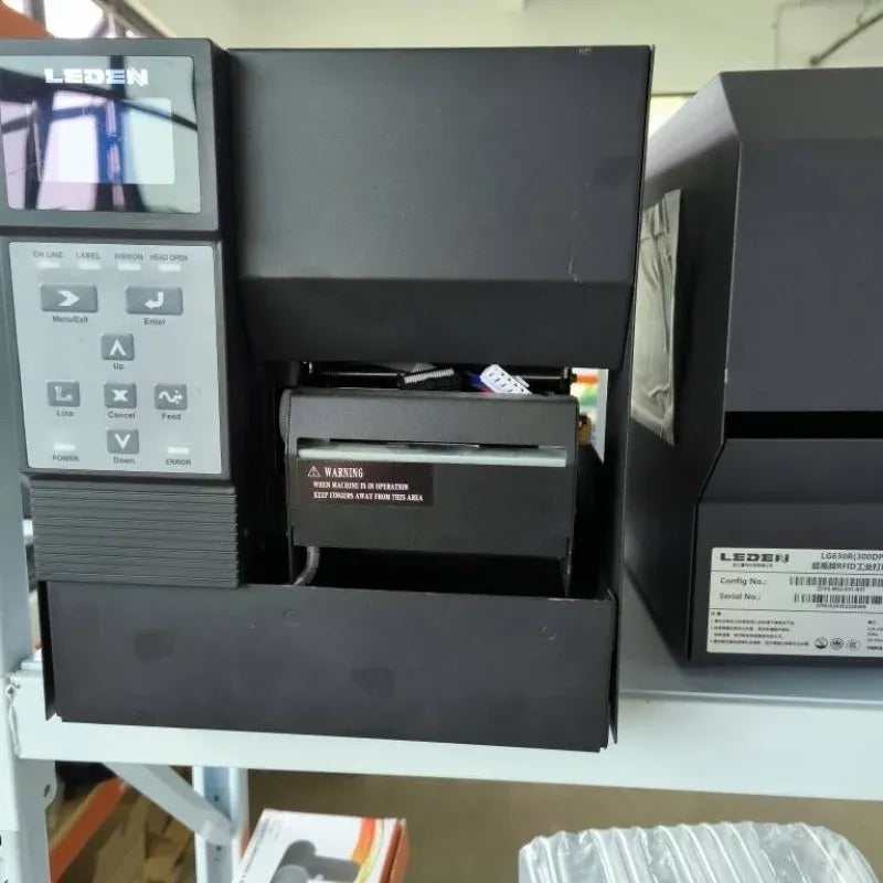 Black thermal transfer label printer front view with open cover and warning label