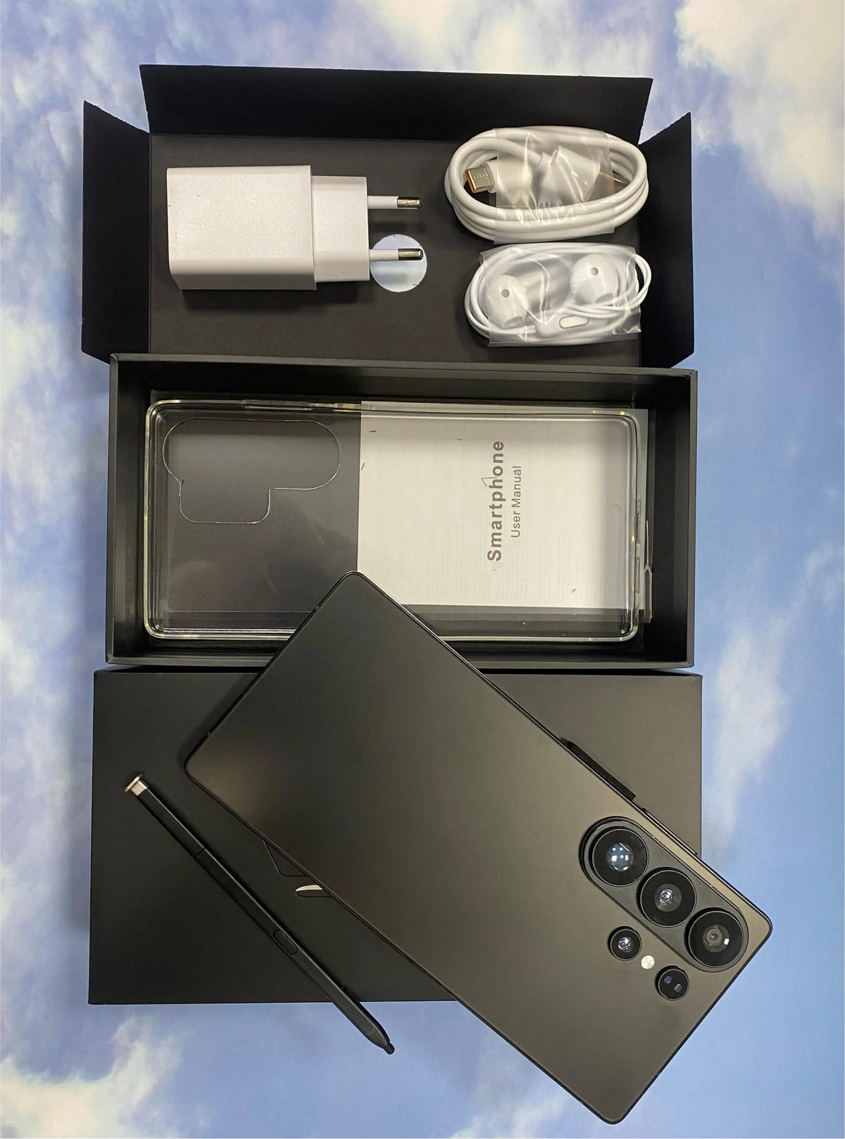 Smartphone unboxing set with dark-gray phone, clear case, charger, and cable