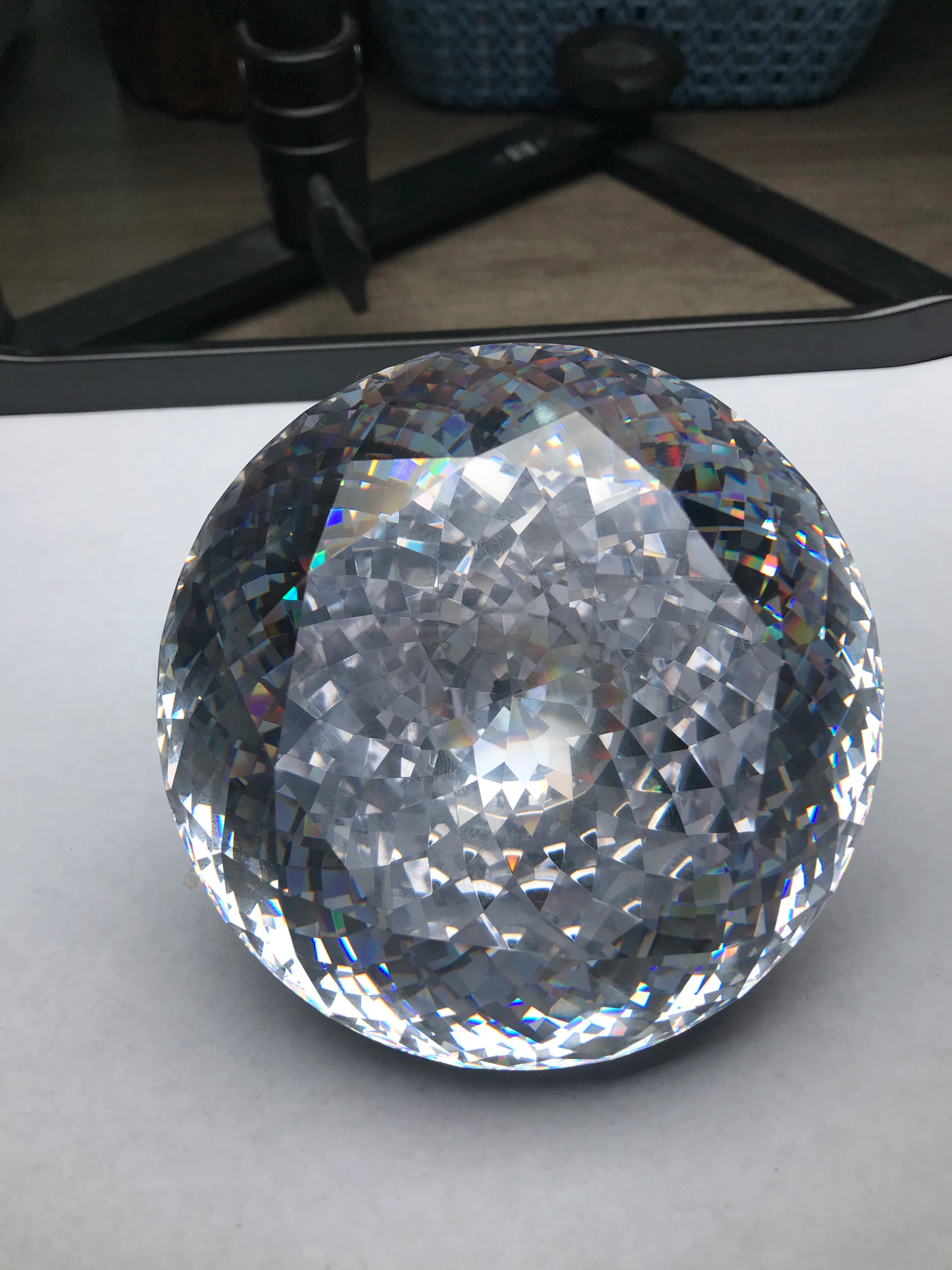 Large round brilliant-cut cubic zirconia gemstone, white, displayed on a stand