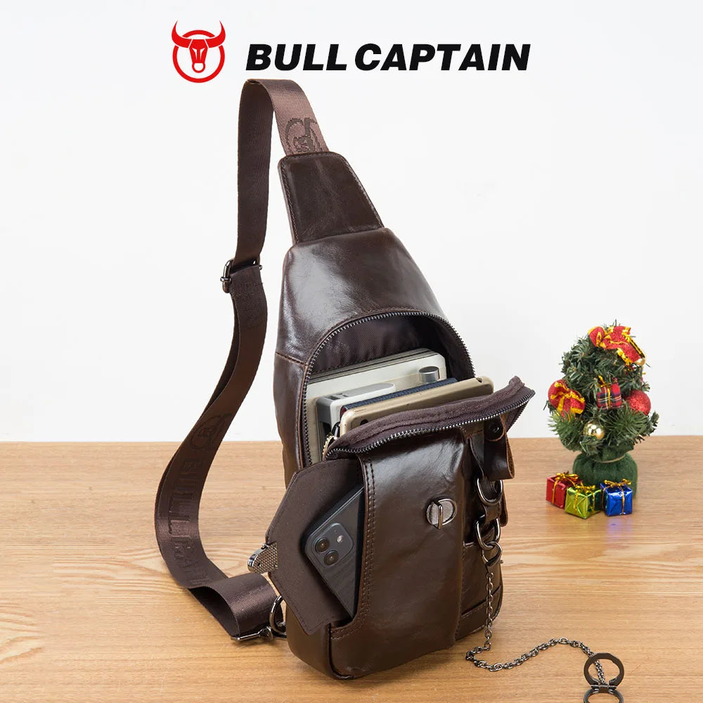 Brown genuine leather BULLCAPTAIN sling bag with crossbody strap, chain detail, and front cellphone storage pocket.