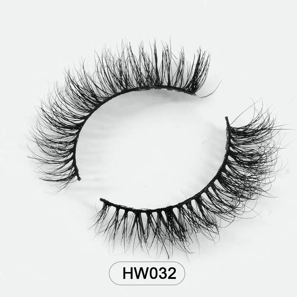 Pair of voluminous black 3D mink false eyelashes with a flexible band on a white background, labeled HW032.