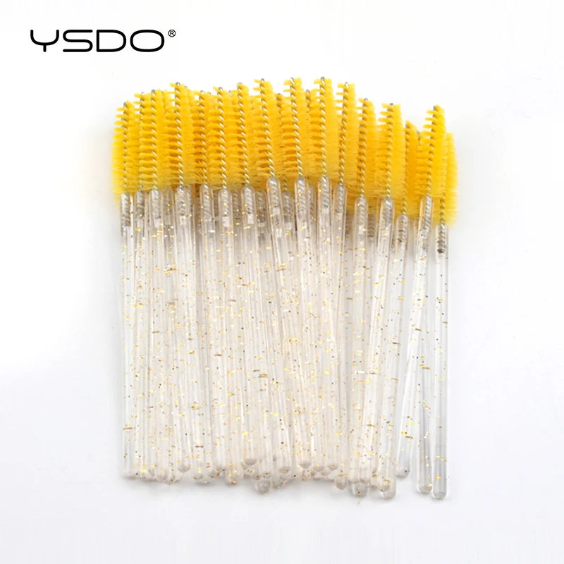 Disposable mascara wands with bright yellow nylon brush heads and clear glitter-filled plastic handles for lash makeup.