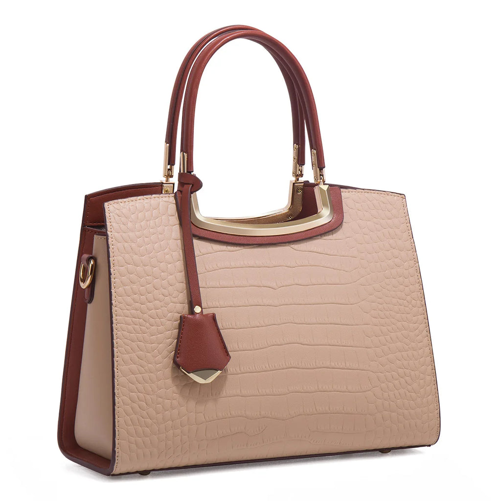 Beige faux croc-skin designer tote bag with brown leather handles, gold hardware, and chic luggage tag detail.