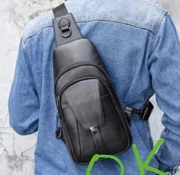 Black genuine leather crossbody designer handbag, modern slim sling style with front pocket and adjustable shoulder strap.