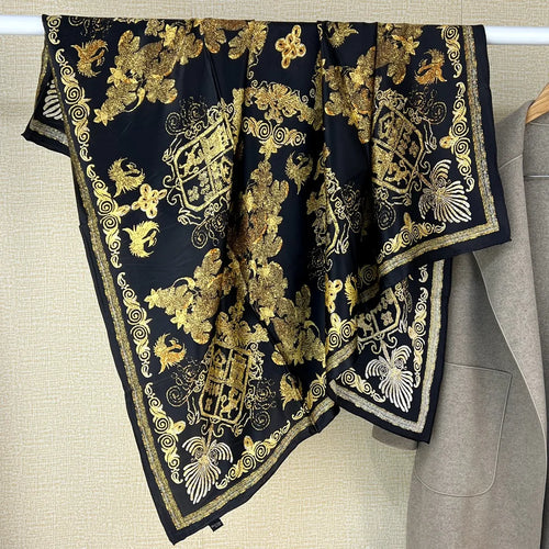 Luxury black silk scarf with gold heraldic crests, floral patterns, and ornate border. Large square designer accessory.