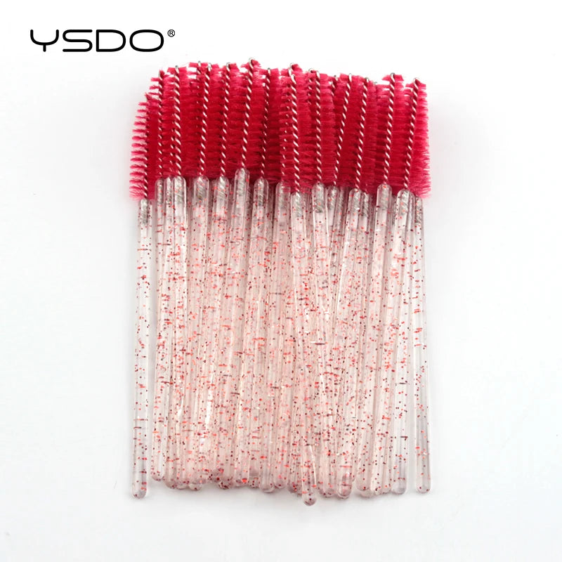Bundle of disposable eyelash spoolie brushes with bright pink heads and clear, red-glitter plastic handles.